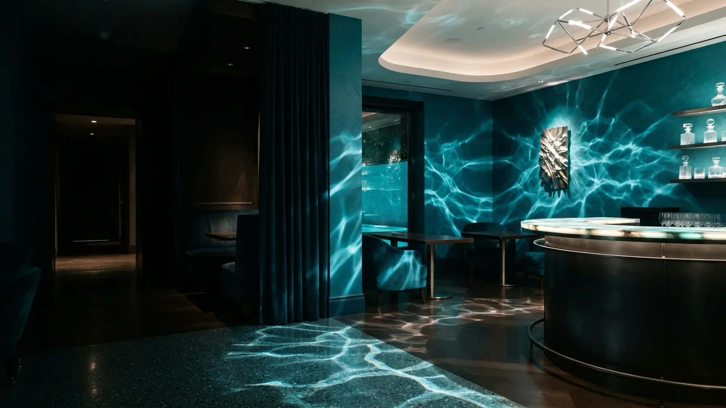 A dark lounge where ripples of light play over teal walls and floor, with a round silver-topped bar and bottle shelves on the right